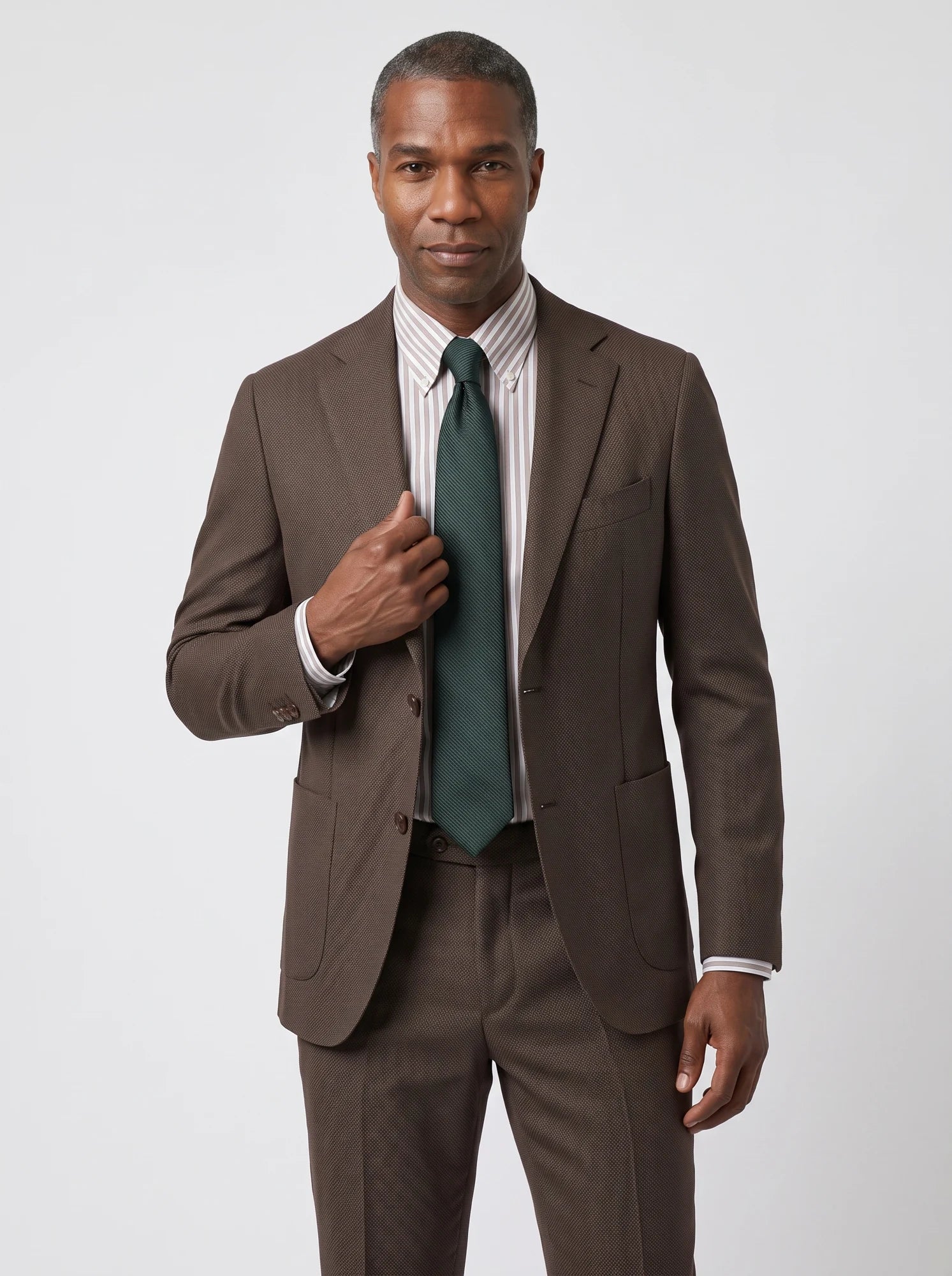 Brown tailoring with a striped shirt and forest-green tie